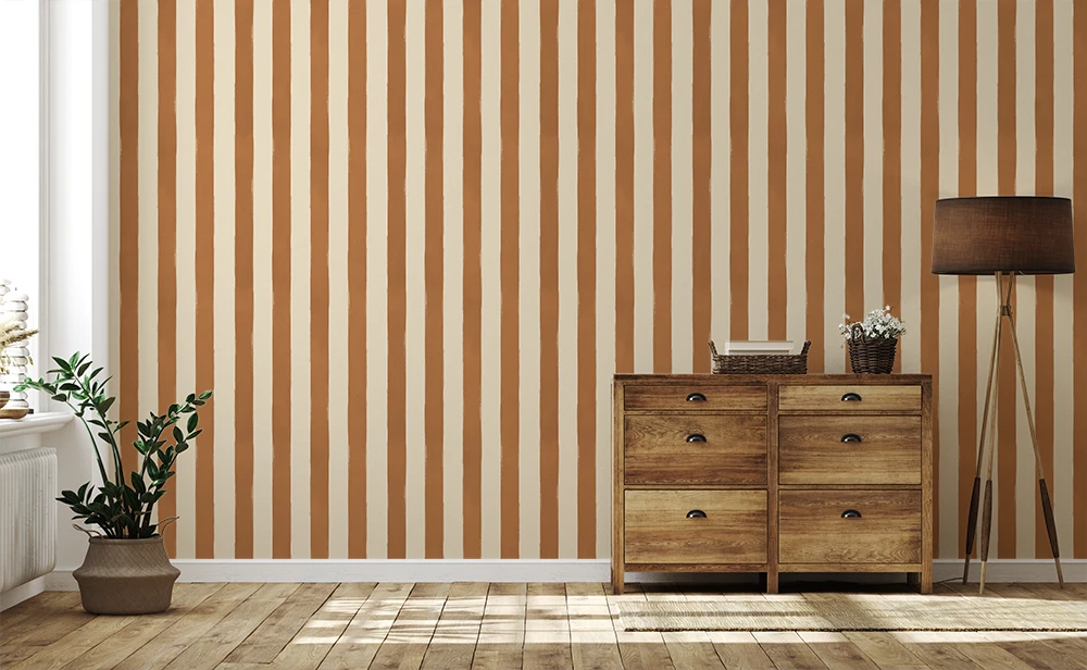 Wooden dresser against a wall with vertical striped caramel wallpaper pattern