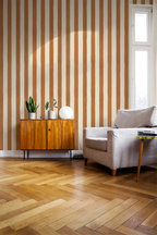 Living room with striped wallpaper, wooden floor, and furniture.