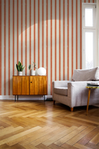 Living room with orange striped wallpaper, wooden floor, and furniture.