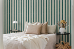 Bedroom with striped wallpaper, bed with pillows, nightstands, and decorative items.