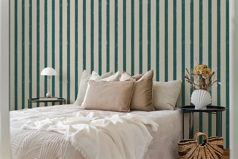 Bedroom with striped wallpaper, bed with pillows, nightstands, and decorative items.