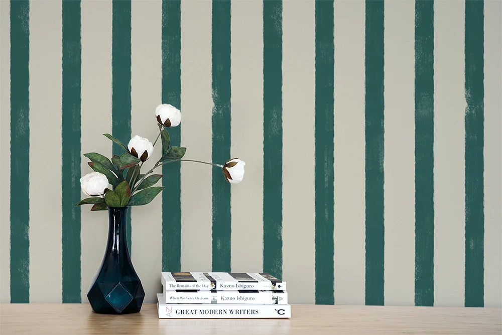 Stack of books with a vase and flowers against a striped wallpaper background