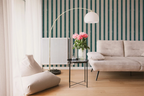 Modern living room with a gray sofa, striped wallpaper, and a floor lamp.