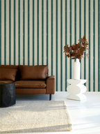 Living room with brown leather sofa, white side table, and striped green and white wallpaper.
