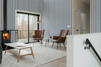 Modern living room with wooden coffee table, brown armchairs, and striped wallpaper.