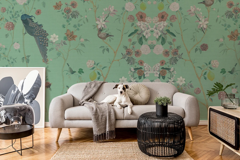 Living room with floral chinoiserie wallpaper, gray sofa, a dog, and decorative items.