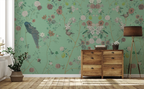 Floral chinoiserie wallpaper with peacocks and flowers, a wooden side table, and a lamp. 
