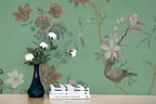 Floral chinoiserie wallpaper, a vase, and books. 