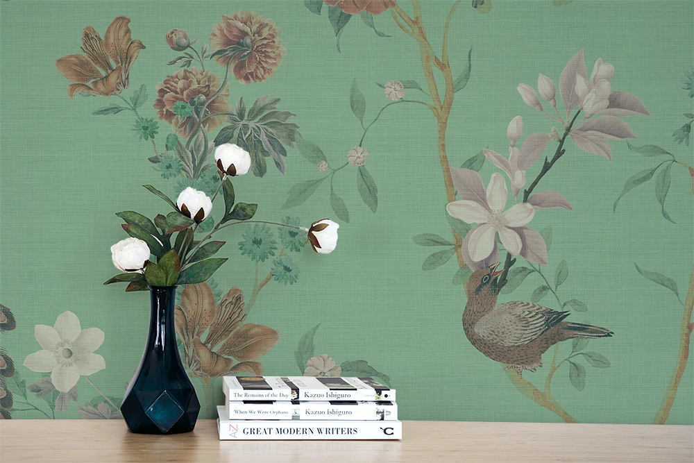 Floral chinoiserie wallpaper, a vase, and books. 