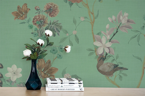 Floral chinoiserie wallpaper, a vase, and books. 
