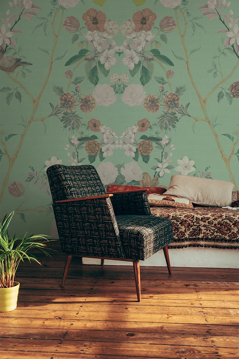 Floral chinoiserie wallpaper in a retro lounge with an arm chair. 