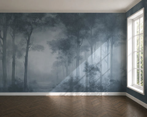A large wallpaper mural depicting a misty blue-gray forest with tall trees and soft sunlight streaming through, shown installed on a room wall above a wood herringbone floor next to a white window.