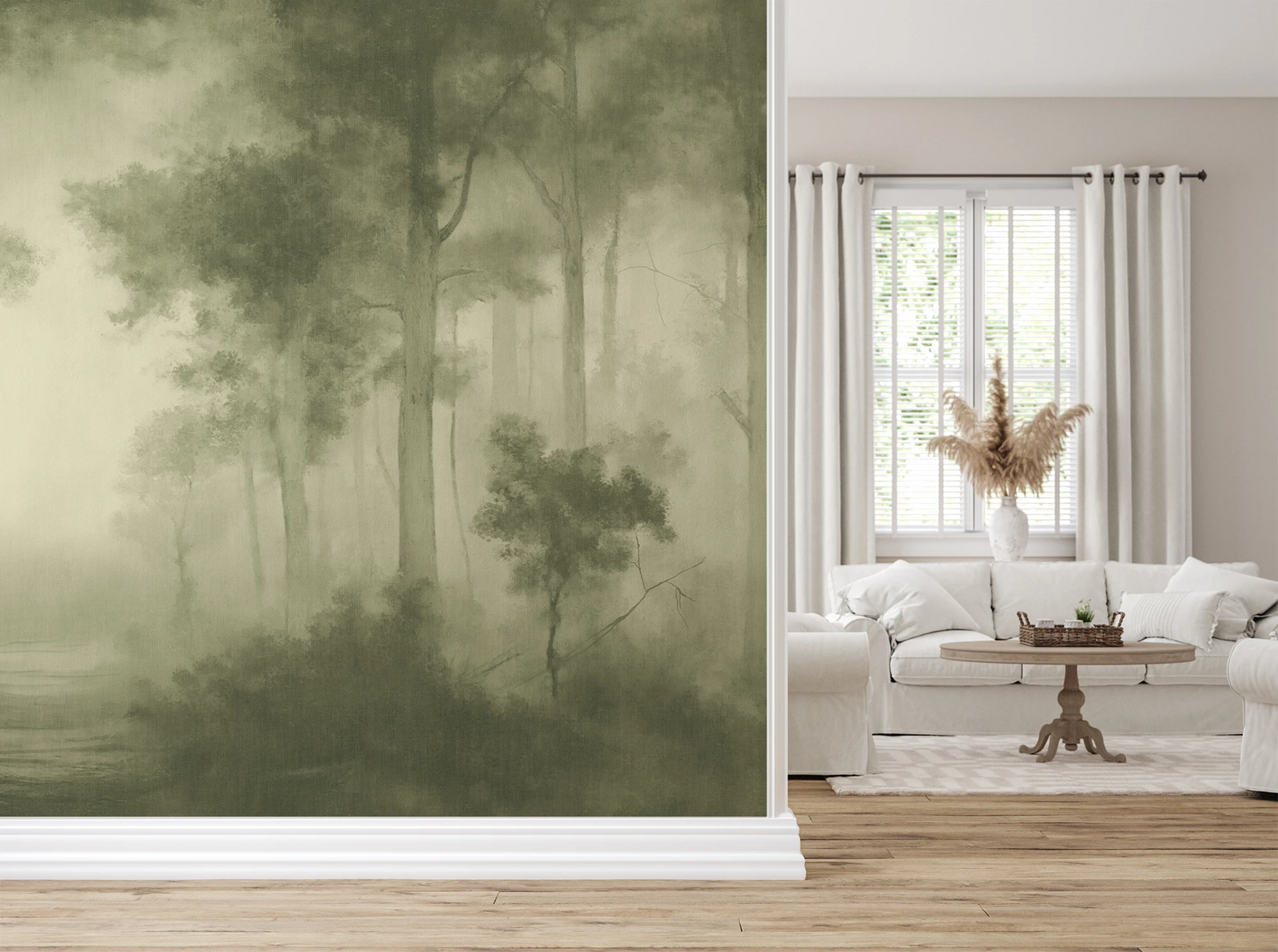 A large wallpaper mural featuring a misty forest scene in muted olive and sage green tones, shown installed on a wall in a bright, modern living room with a white sofa, window, and light wood floor.