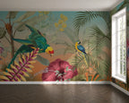 A tropical jungle wallpaper mural featuring colorful parrots, palm leaves, and large pink flowers, shown installed on a room's wall above a dark wood herringbone floor.