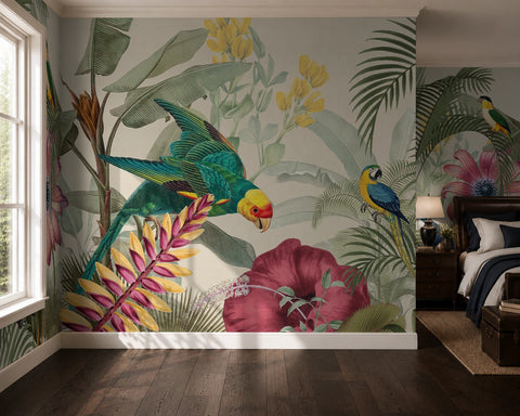 A tropical jungle wallpaper mural featuring colorful parrots, palm leaves, hibiscus flowers, and yellow blossoms, shown installed on a bedroom wall above a dark wood floor next to a bed.