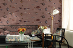 A living room with a dusty rose wallpaper with a pattern of vintage fish illustrations drawn by Marcus Elieser Bloch, a black arm chair, and a daybed in black. 