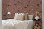 Modern bedroom with a white bed and beige pillows, and a wallpaper pattern with vintage marine life illustrations. 
