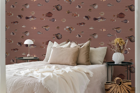 Modern bedroom with a white bed and beige pillows, and a wallpaper pattern with vintage marine life illustrations. 
