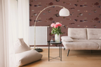 A modern living room with a white sofa, a vase, a floor lamp, and a wallpaper with a brown background featuring a pattern of vintage marine life illustrations. 