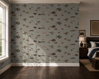 An elegant bedroom with wooden furniture, and a wallpaper with a greige background featuring a pattern of vintage marine life illustrations. 