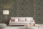 A styled living room featuring a sage green wallpaper with a repeating pattern of small fish in muted earthy tones. In front of the wall is a light pink sofa with matching pillows, a floor lamp, and a wooden coffee table.