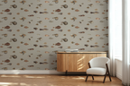 Lounge room with a wooden side table, a white arm chair, and a wallpaper with a greige background featuring a pattern of vintage marine life illustrations. 