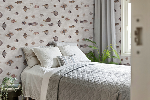 Bedroom with Scandinavian decor, and a wallpaper with incredible vintage fish illustrations drawn by Bloch. 