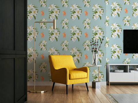 A styled living room corner featuring light Tiffany blue wallpaper with a white lily floral pattern with small tigers, a bright yellow armchair, a gold floor lamp, and a white sideboard with a TV mounted on the wall.