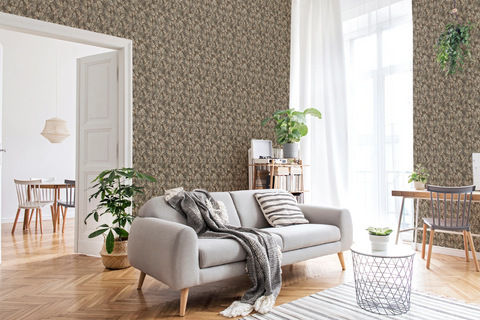 A modern living room with a grey sofa, green plants, and a wall featuring a tapestry wallpaper in an oak leaf pattern. 