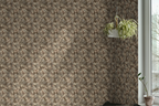 A  wall featuring a tapestry wallpaper in an oak leaf pattern, a pot hang from a string, next to a window to the outside. 