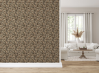 A modern living room, with white textile furniture, a large vase with a beige flower, and a wall featuring a tapestry wallpaper in an oak leaf pattern. 