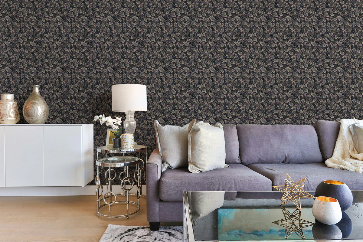 Modern living room with a blue sofa, a glass sofa table, and a wall with a tapestry wallpaper featuring a dark oak leaf pattern. 