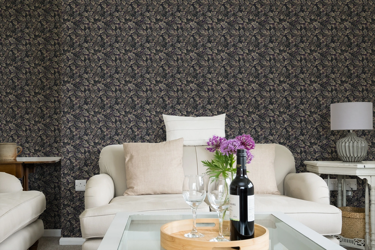 Modern living room with a white sofa, a glass sofa table, and a wall with a tapestry wallpaper featuring a dark oak leaf pattern. 