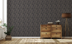 A living room with wooden cabinet, a floor lamp, plant, and a wall with a tapestry wallpaper featuring a dark oak leaf pattern. 