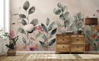 Botanical floral wallpaper with pastel flowers and green foliage behind a rustic wooden chest and woven baskets.