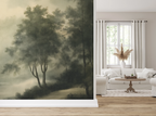 A hallway leading into a living room with a white lounge chair and white sofa, and a wallpaper featuring a vintage forest in green, with a texture of a painting. 