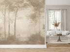 A large wallpaper mural featuring a misty forest scene in soft sepia tones, shown installed in a living room next to a window with white curtains and a light-colored sofa.