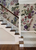 A staircase interior with floral wallpaper, a white stairwell, dark wood steps and rail, and a light carpet runner.