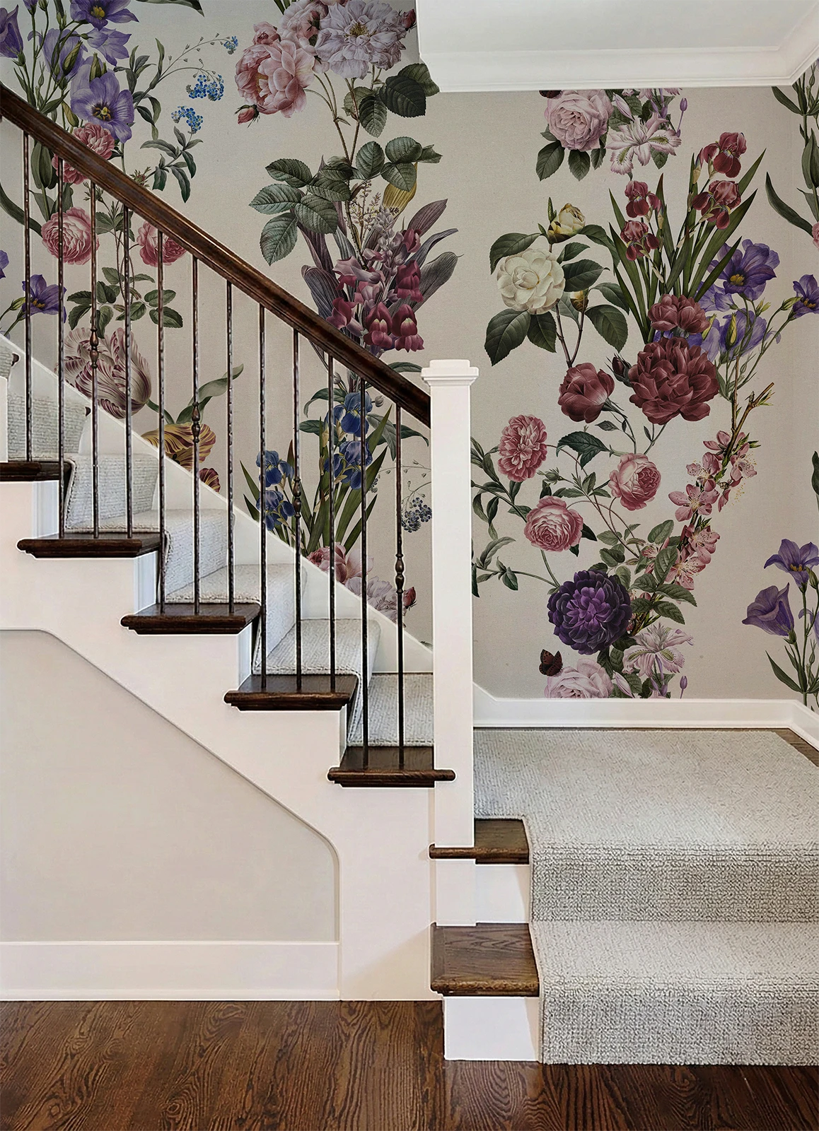 A staircase interior with floral wallpaper, a white stairwell, dark wood steps and rail, and a light carpet runner.