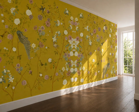 A wall with chinoiserie wallpaper with a yellow background, featuring flowers and peacocks. 